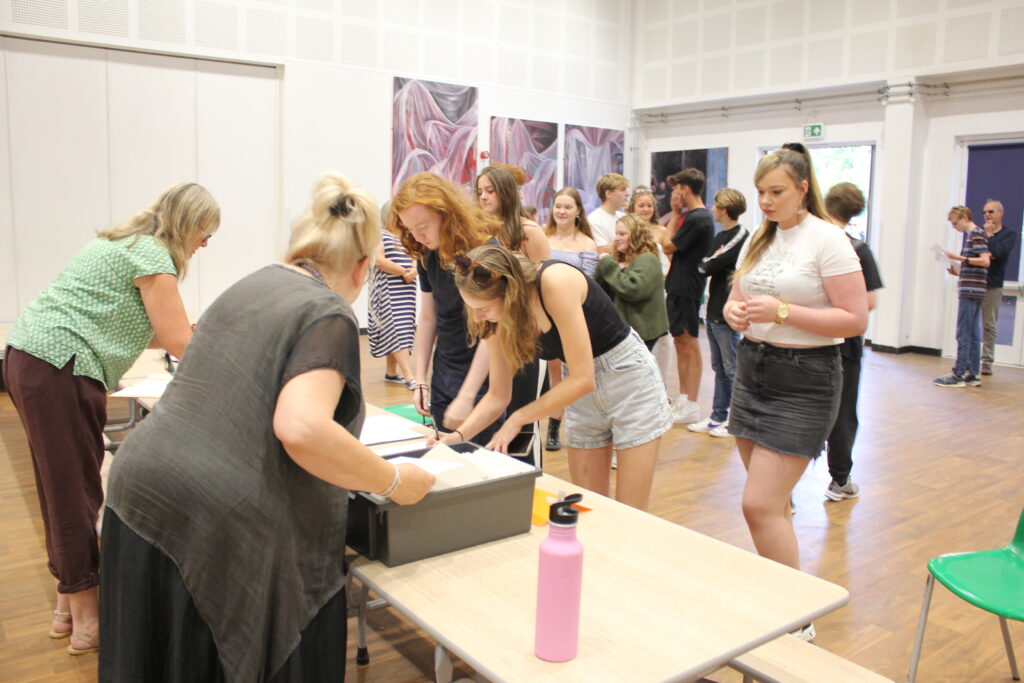 Groups of Post-16 students and their parents are pictured gathering in the main hall to receive their A-Level results.