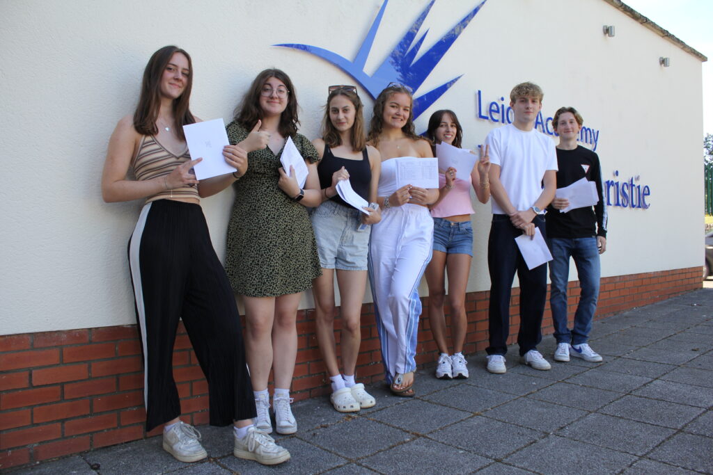 A group of Post-16 students are pictured standing alongside one another and smiling for the camera, after having just opened their A-Level results.